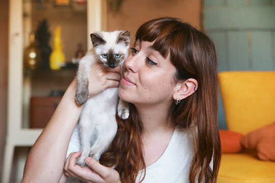 Young woman with kitten at home