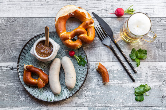 White sausage breakfast with pretzels, mustard and beer