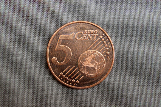 Five euro cent coin isolated on gray fabric background