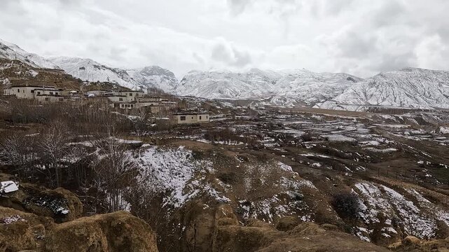 Panning view over Yara Gaun village amid snow dusted eroded cliffs, Upper Mustang, Nepal