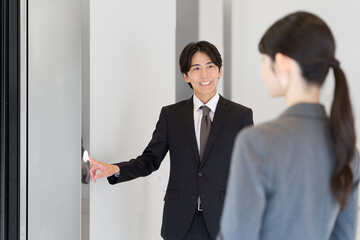 エレベータで先に譲るアジア人ビジネスマン © mapo
