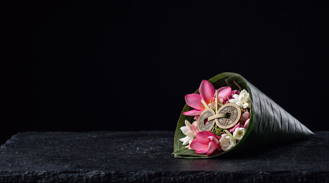 Balinese traditional canang sari offering with plumeria flowers and coins for Purnama and Tilem background