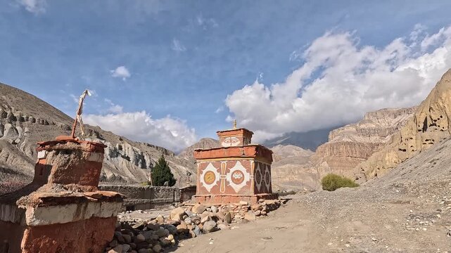 Slow approach to painted chortens with Buddha eyes and mandala motifs against eroded cliffs, Chhusang, Upper Mustang, Nepal