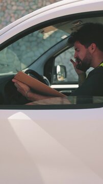 Delivery driver talking on the phone inside a van