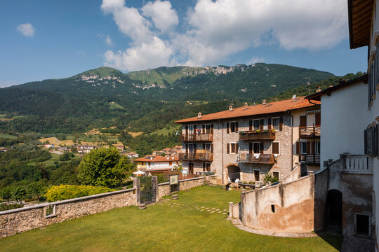 Traditional stone buildings and green garden courtyard showcase a serene tourism destination, Monte Baldo Natural Park, Palazzo Baisi e Giradino dei Semplici, Brentonico, Trentino, Veneto, Italy.