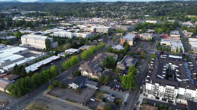 Majestic mountains overlook expanding commercial districts near Central Kent, King County, suburbs Seattle. Elevated views highlight structural density within evolving urban centers found in WA