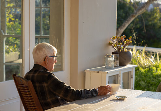 elderly man sipping tea outdoors at sunset
