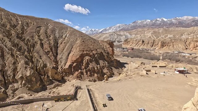 revealing shot Cave window view snow peaks prayer scarves Jhong Chhoser cave Upper Mustang Nepal