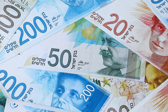 Israeli new shekel money bills in pile on table. Israel ILS currency cash close up