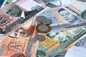 Cambodian riel money banknotes and coins on table. Cambodia cash bills of KHR currency © Viktor