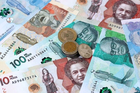 Colombian peso money banknotes and coins on table. Colombia cash bills of COP currency