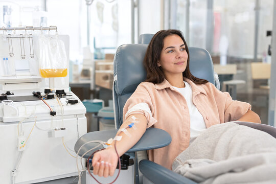Calm platelet donor beside modern apheresis machine