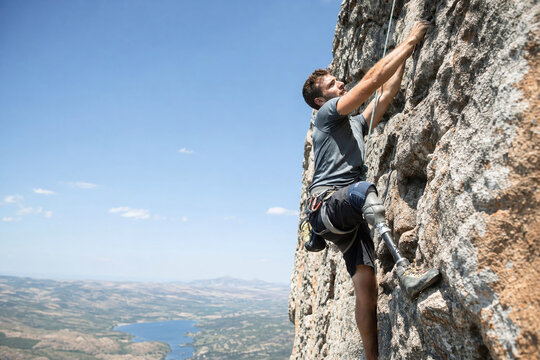 Adaptive climber scaling cliff with prosthetic leg