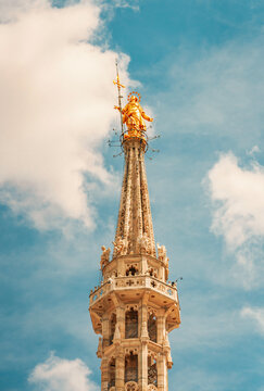Golden Madonnina statue shining on the highest spire of Milan Cathedral.