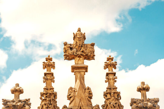 Detailed view of decorative gothic statues and carvings on Milan Cathedral roof.