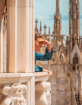Smiling woman exploring the rooftop of Milan Cathedral on a sunny day.