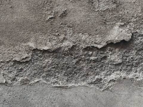 Grunge damaged concrete wall texture background. Chipped peeling plaster surface with deep crack and rough cement layer. Old weathered architectural backdrop.
