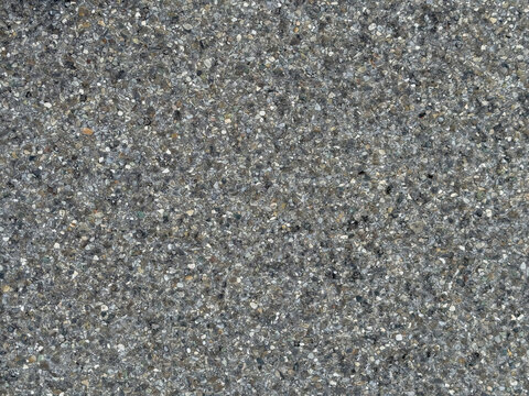 Fine grain asphalt texture background. Dark grey road surface with small crushed stones. New tarmac pavement backdrop for transportation and logistics.