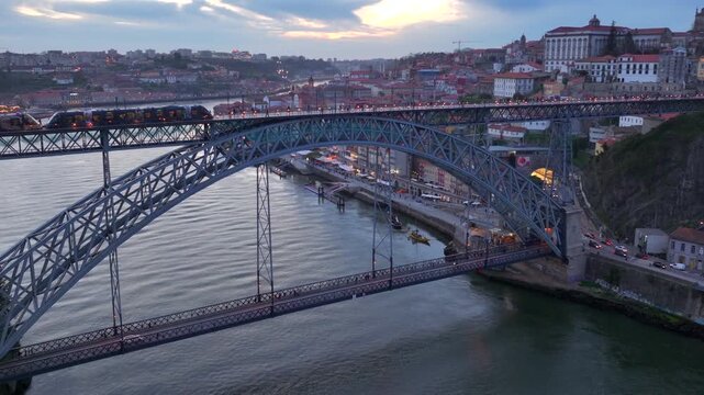 Illuminated Evening Porto City with Dom Luis I Bridge over Douro river. Aerial Shot over Night Lights and Infrastructure
