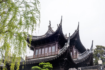 Obraz premium Curved tiled roof and carved wooden eaves at Jade Buddha Temple in Shanghai, China, spring day