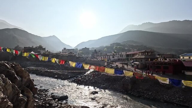 Colorful prayer flags strung over Kali Gandaki river, village buildings, Kagbeni Sangam Nepal