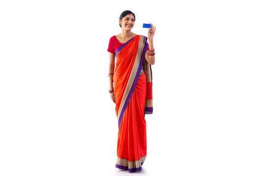 Portrait of a young woman holding a credit card against white background