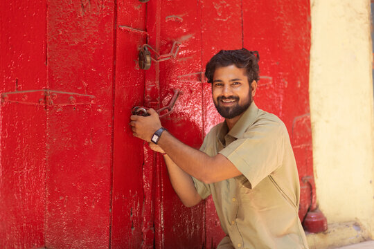 Portrait of a happy young man unlocking door