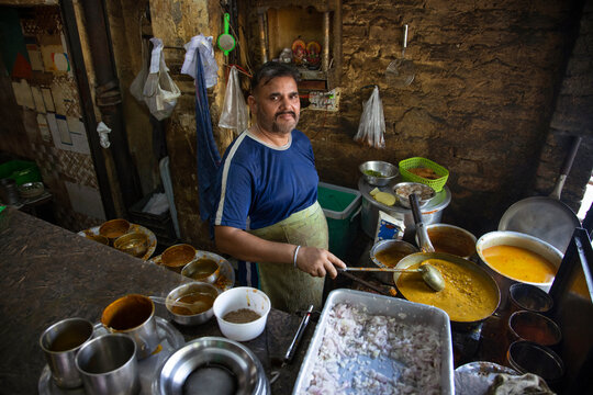 A cook and an owner of a local roadside restaurant or a  dhaba,cooking food during lunch hour