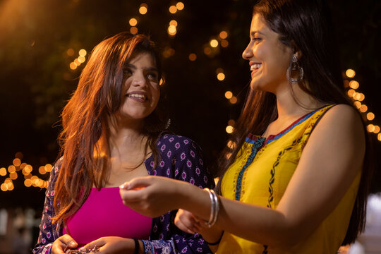Cheerful woman selecting bangles with her friend