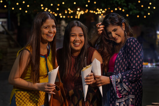 women having fun and eating Jhalmuri on street