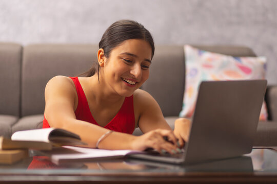 Portrait of a teenage girl doing homework during online classes