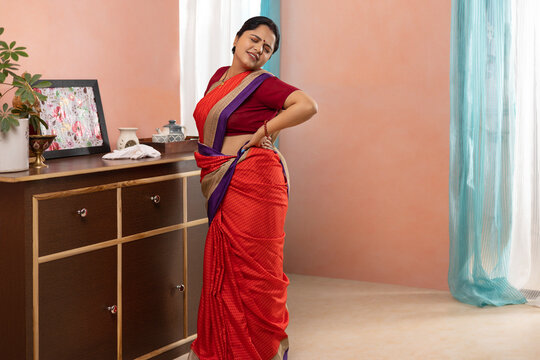 Woman suffering from back pain while cleaning house