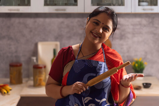 Portrait of happy woman with rolling in hand looking at camera