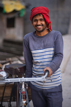 Portrait of a rickshaw puller with his rickshaw and his workload 