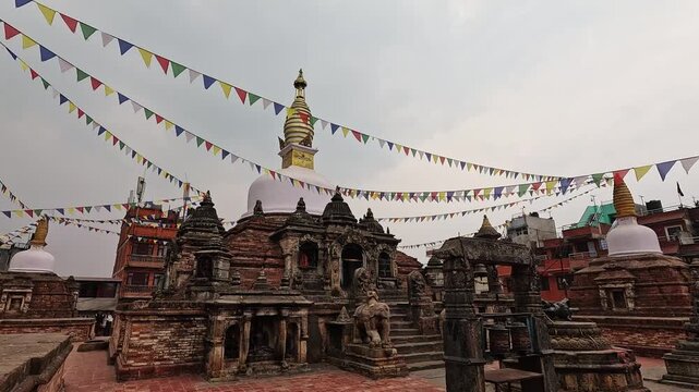 Chilancho Stupa compound wide shot, ornate brick base structures with elephant statues and prayer flags, Kirtipur, Nepal