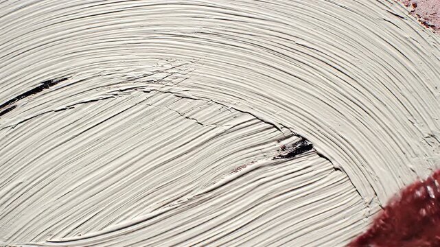 A close-up shot captures the textured application of red and black paint onto a canvas, showcasing the artist's brushstrokes and the tactile quality of the medium.