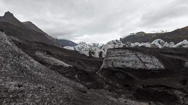 Svinafellsjokull on-glacier jagged ash-streaked seracs with blue ice cores and crevasse hole, Iceland
