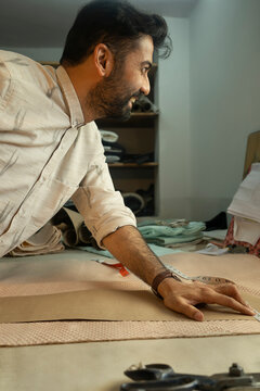 Fashion designer tracing patterns on the cloth 