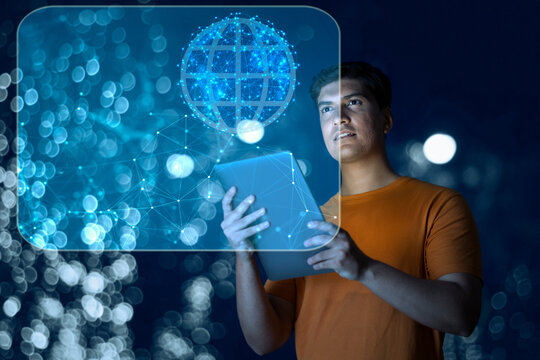 Young man uses digital tablet on virtual visual screen at night 