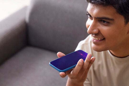 Close-up of young man talk with virtual digital voice recognition assistant