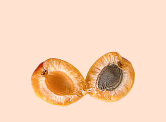 Fresh apricot halves with pit on pastel background healthy summer stone fruit with copy space © Ольга Клецкова