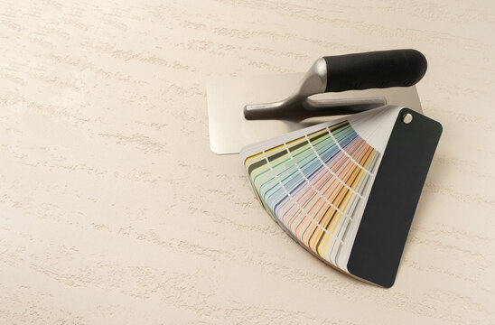 Plastering Trowel and Color Swatch Fan on Travertine Effect Decorative Plaster Surface