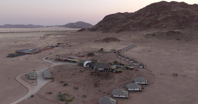 Aerial view of a desert lodge surrounded by vast arid plains near the Namib-Naukluft National Park in Namibia.