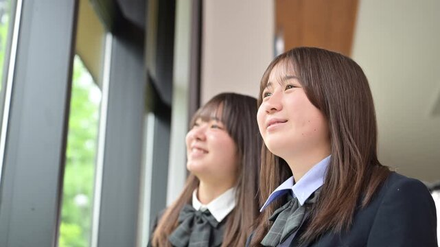 [スローモーション]窓の外を見つめる日本人女子高校生複数 将来・進路・希望などの青春や学校イメージのクローズアップの動画