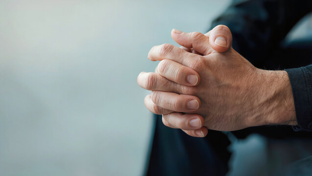 Clasped hands of man in contemplation or worry