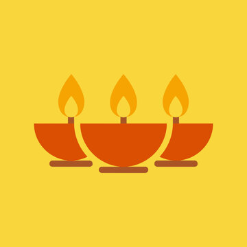 Three burning clay lamps for Diwali festival on a yellow background