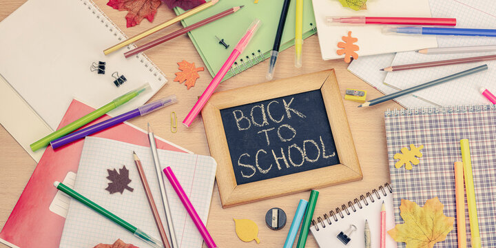 Back to school concept. Fall leaves, chalkboard with text. Business background with office supplies
