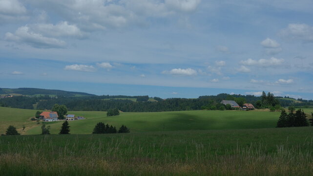 Rolling Green Hills and Rural Countryside Under Dramatic Cloudy Sky