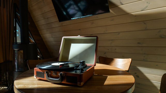 Vintage record player on a wooden table in a cozy cabin setting