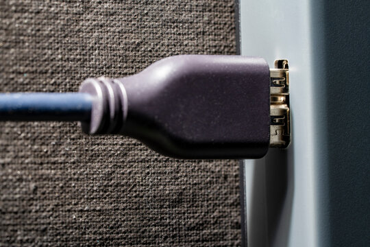 DisplayPort cable plugged into device port closeup. Macro view black digital interface cable connected to electronic device socket. Concept of data transfer, high tech connection and hardware setup